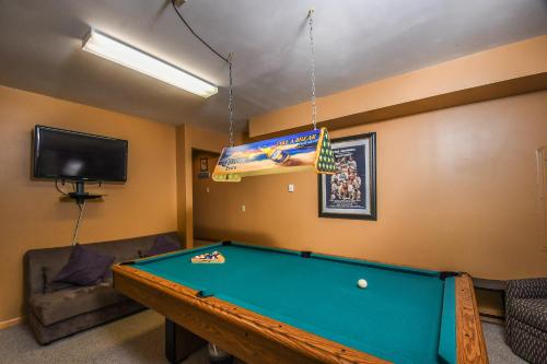 a living room with a pool table and a tv at Sparkys Lodge in McHenry