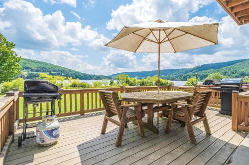 a wooden deck with a table and an umbrella and a grill at Ski Harbor 11 in McHenry