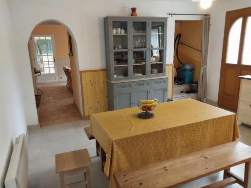 une cuisine avec une table avec un bol de fruits dessus dans l'établissement Maison de vacances Clos du Bayle, à Sagriès