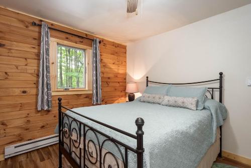 een slaapkamer met een bed en een houten muur bij Lincoln Log Cabin in Oakland