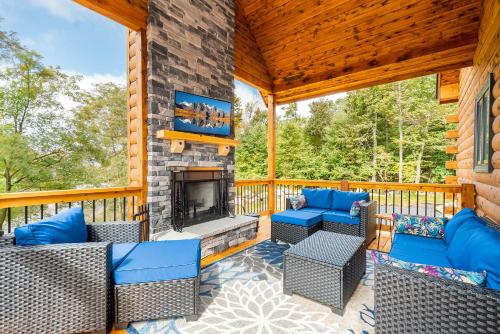 a screened porch with furniture and a fireplace at Sunshine Chalet in McHenry