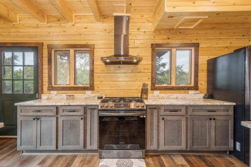 a kitchen with wooden walls and a stove at Sunshine Chalet in McHenry