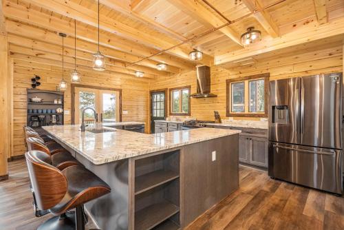a kitchen with a large center island in a log cabin at Sunshine Chalet in McHenry