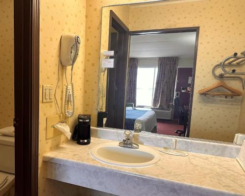 a bathroom with a sink and a phone on the wall at Travelodge by Wyndham Seymour in Seymour