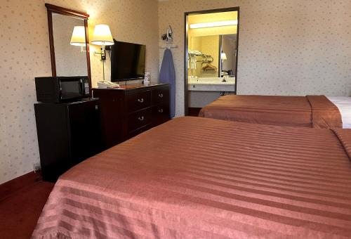 a hotel room with two beds and a television at Travelodge by Wyndham Seymour in Seymour