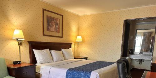 a hotel room with a bed and a window at Travelodge by Wyndham Seymour in Seymour
