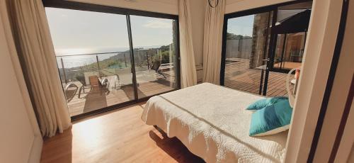 - une chambre avec une grande fenêtre donnant sur un balcon dans l'établissement Gaou - Villa ONEIROS, paisible avec piscine & vue mer, à Bormes-les-Mimosas