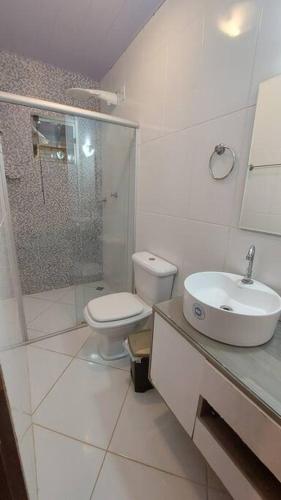 a white bathroom with a toilet and a sink at Chalé Beira Rio Cipó in Serra do Cipo