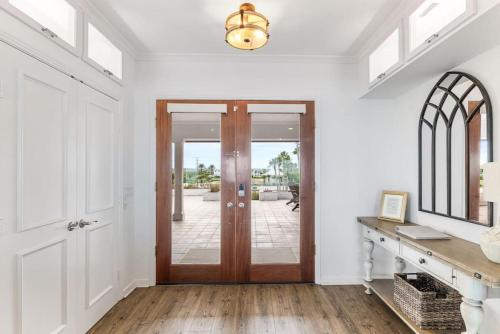 a hallway with a wooden door and a mirror at Island Time -- Oceanfront Bliss in Saint Augustine