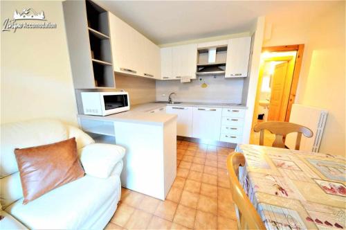 een kleine keuken met een bank en een magnetron bij Appartamenti Barin by Livigno Accomodation in Livigno