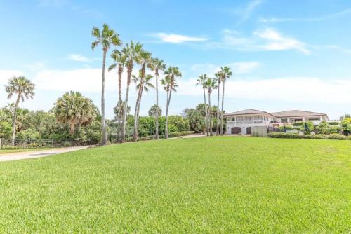 a large yard with palm trees and a house at Island Time -- Oceanfront Bliss in Saint Augustine