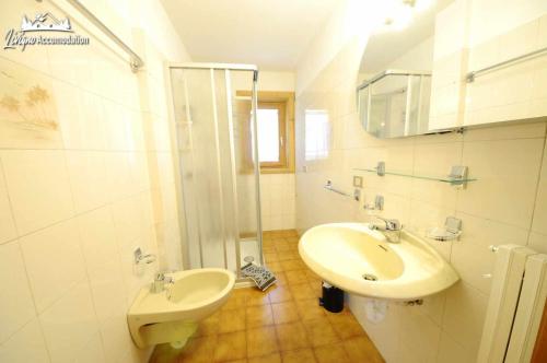 y baño blanco con lavabo y ducha. en Appartamenti Barin, en Livigno