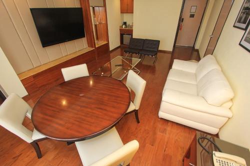 a living room with a wooden table and white chairs at Holiday Inn Leon by IHG in León