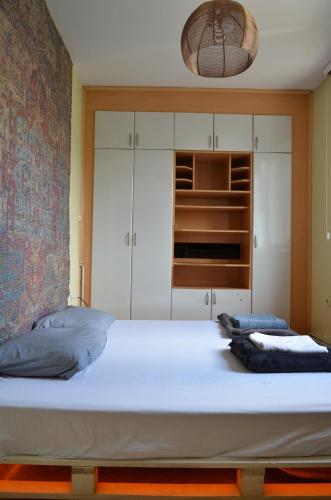 プリシュティナにあるCenter House Hostelのベッドルーム(白い大型ベッド1台、キャビネット付)
