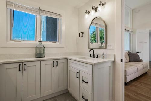 a white kitchen with a sink and a mirror at Crescent Lookout Oceanfront with panoramic views in St. Augustine