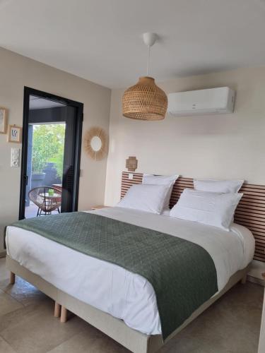 a bedroom with a large bed with a green blanket at La Suite in Brie