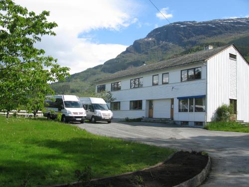 
a white van parked in front of a white house at Hardanger Hostel B&B in Lofthus
