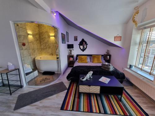 TIFFY'S PLACE Adult Guest House في بلاكبول: غرفة نوم مع سرير وحوض استحمام في غرفة