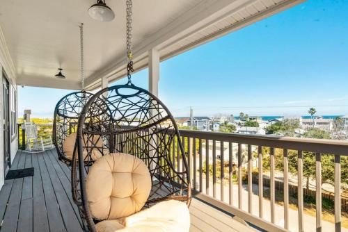a porch with two swing chairs on a balcony overlooking the ocean at St Augustine Rose Ocean Heated Private Pool in Saint Augustine