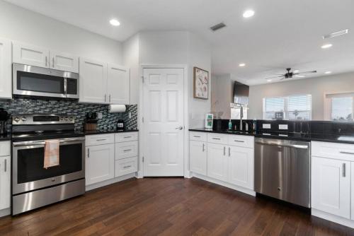 a kitchen with white cabinets and stainless steel appliances at St Augustine Rose Ocean Heated Private Pool in Saint Augustine