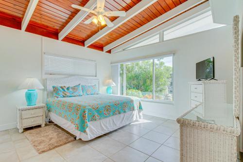 a bedroom with a bed and a ceiling fan at Downhome Cabin by the Canal in Key Colony Beach