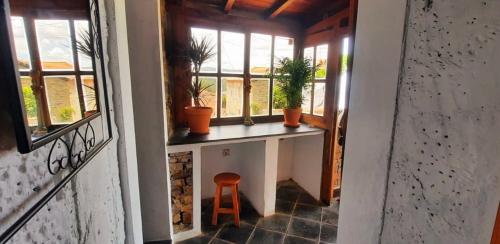 a room with a window with a stool and plants at Castelinho in Raiva