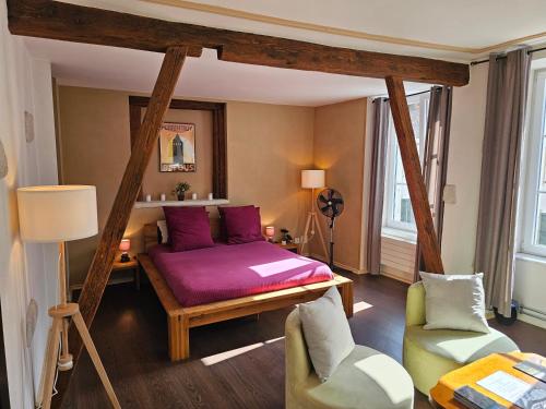 a bedroom with a bed and a couch and chairs at La Croix Fédérale in Porrentruy