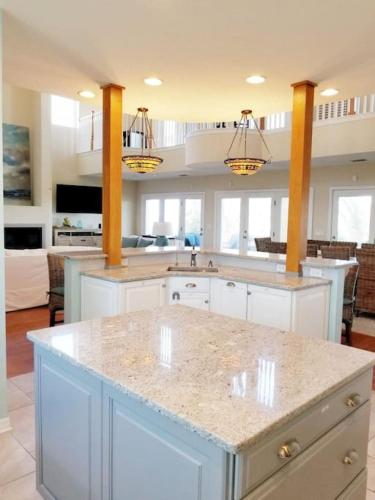 a kitchen with white cabinets and a large island at The Sand Castle Heated Pool Atlantic Ocean in St. Augustine