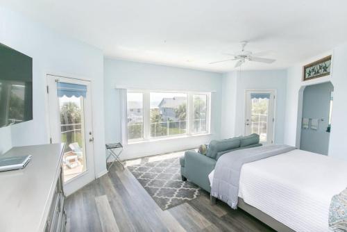 een slaapkamer met een bed, een bank en ramen bij The Sand Castle Heated Pool Atlantic Ocean in St. Augustine
