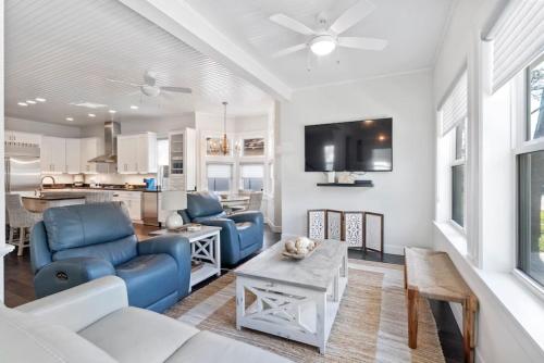a living room with blue furniture and a kitchen at Cobalt Cottage History at your doorstep in St. Augustine