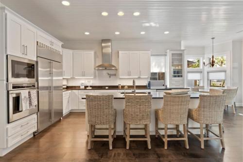 a kitchen with white cabinets and a table with chairs at Cobalt Cottage History at your doorstep in St. Augustine