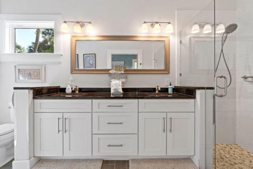 a bathroom with a sink and a mirror at Cobalt Cottage History at your doorstep in Saint Augustine