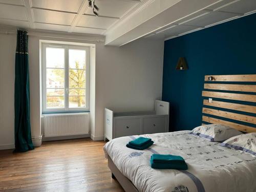 una camera da letto con un letto grande e una parete blu di Maison de maître du 19ème siècle à la campagne a Bellenod-sur-Seine