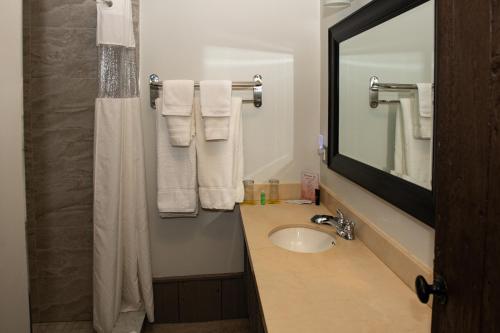 uma casa de banho com lavatório, espelho e toalhas em Benmiller Inn & Spa em Goderich