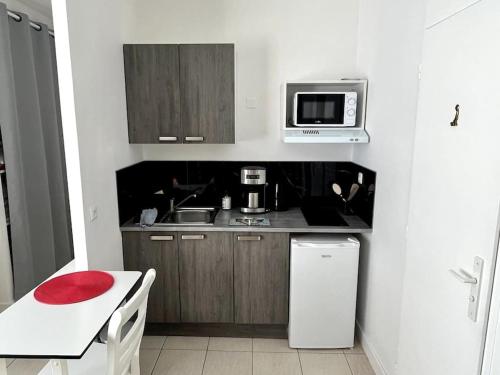 une petite cuisine avec un comptoir et un micro-ondes dans l'établissement Appartement avec extérieur, à Loos