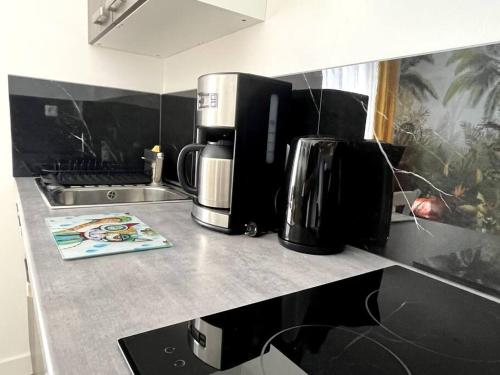 a kitchen with a counter top with coffee makers on it at Appartement avec extérieur in Loos