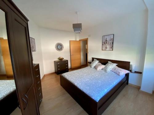 a bedroom with a bed and a dresser in it at Lar dos Galos in Bueu