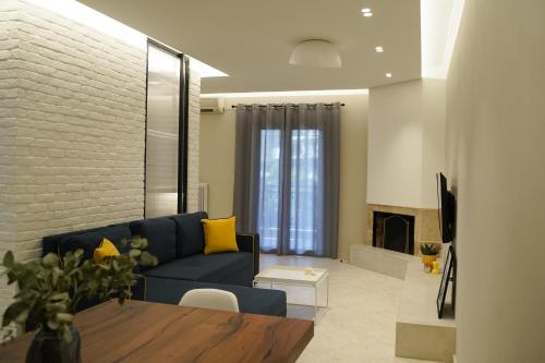 卡蘭巴卡的住宿－Grand View Suites Meteora，客厅设有蓝色的沙发和壁炉