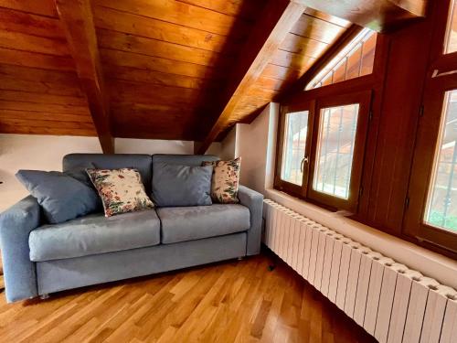a couch sitting in a room with windows at Paradise - nature and wellness in Pino Torinese