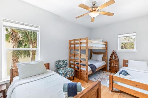Un dormitorio con dos camas y un ventilador de techo. en Seamora Ocean Hot Tub Firepit, en St. Augustine