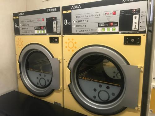 two washing machines sitting next to each other at 大阪長居港湾客房 in Osaka