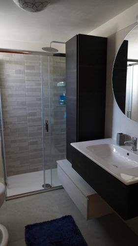 een badkamer met een douche, een wastafel en een toilet bij Casa Della Nonna in Cisternino