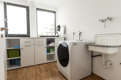 a bathroom with a washing machine and a sink at NECKARWESTHEIMER Appartement in Neckarwestheim