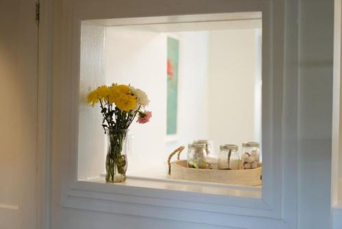 a window with a vase with flowers on a shelf at Casa Blanca Casita by the Ocean in St. Augustine