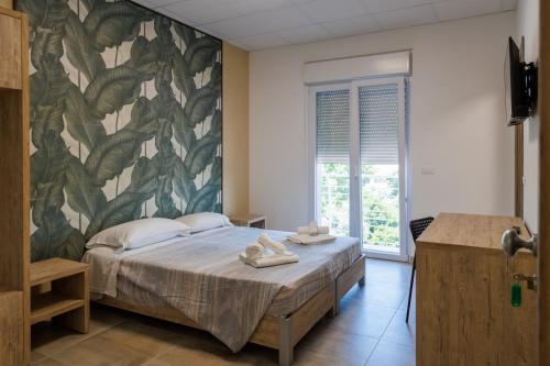 a bedroom with a large bed with a leafy wall at Affittacamere Flavia Roma in Ostia Antica