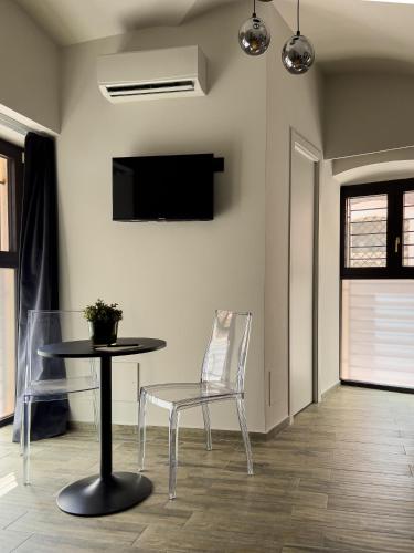 a table and chair in a room with a tv at VICOLO SAN GAETANO -luxury rooms- in Catania