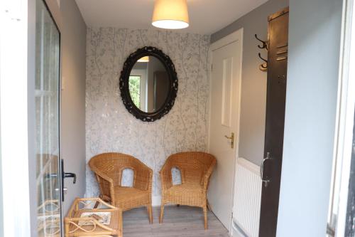 a hallway with wicker chairs and a mirror at The Loft at Craigmill House in Blairgowrie