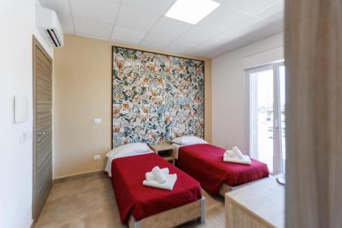 two beds in a room with red cushions at Affittacamere Flavia Roma in Ostia Antica