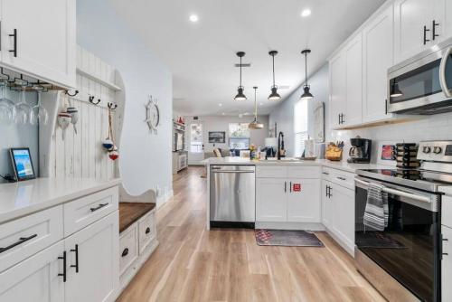 a large white kitchen with wooden floors and white cabinets at Lions Sail Beach Island Pool in St. Augustine