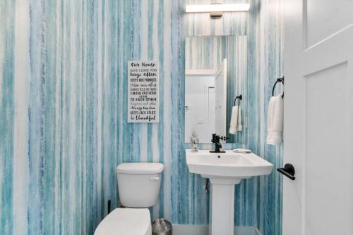 a bathroom with a white toilet and a sink at Lions Sail Beach Island Pool in Saint Augustine